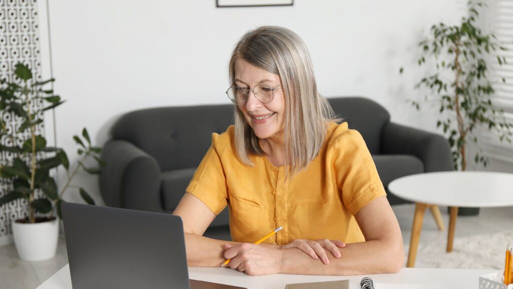 Woman on video call noticing neck and jawline appearance on laptop